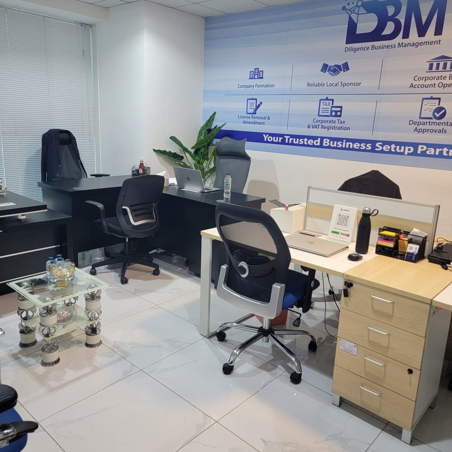 DBM team workstations in front of the services wall listing company formation, tax and visa services